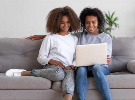 A parent and student researching scholarships together at home