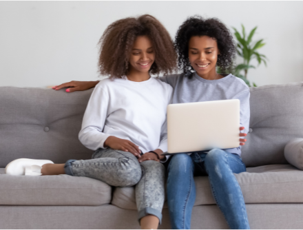 A parent and student researching scholarships together at home