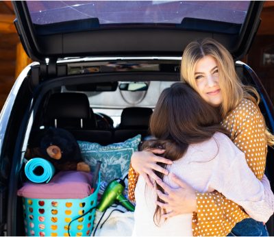 Sudie's daughter hugging her at the packed car, leaving for her dream college