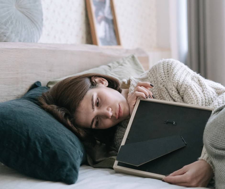 student laying in bed thinking about home