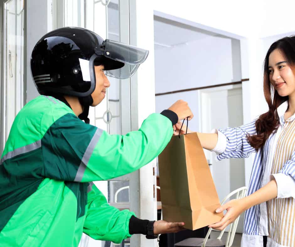 teen delivery driver on a motorcycle delivering food