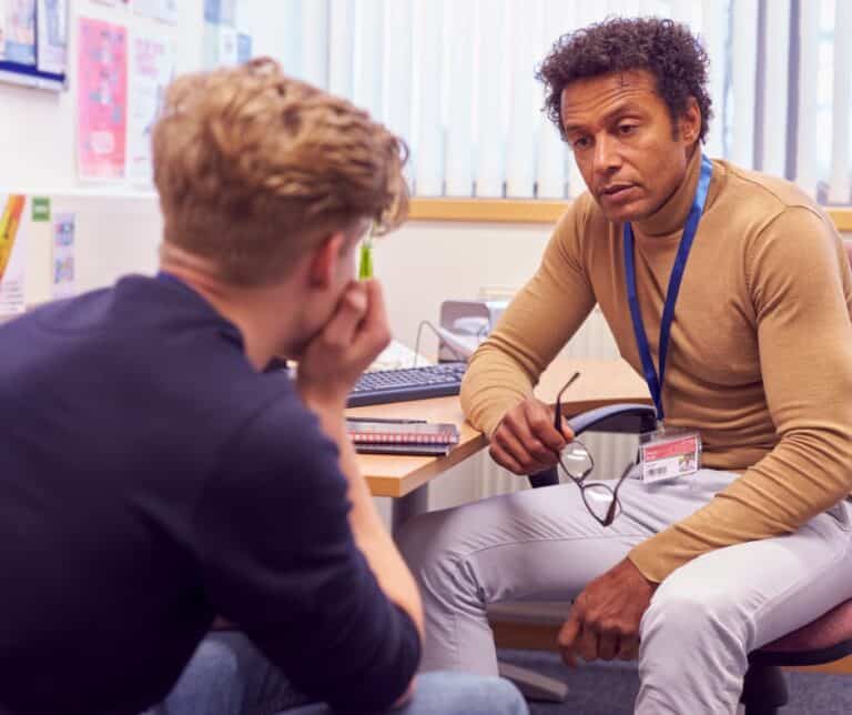 male college student speaking with a campus counsellor about mental health issues