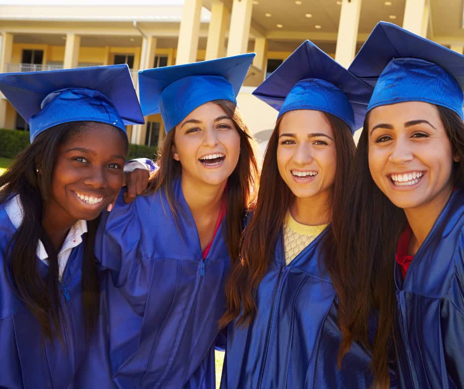 high school students in blue robes grating from high school